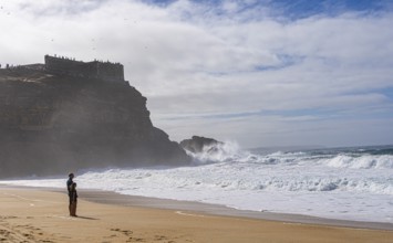 Tourists watch the waves of the Atlantic on the rocky plateau of Sito, also known as Forte São