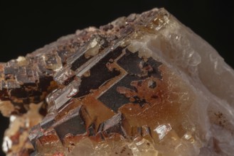 Transparent crystals sit on rocks and reveal their unique shimmer and geological structure. The
