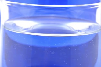 Glass with mineral water, small carbonated pearls on the edge of the glass, drinking water