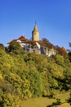 A castle with a tower, highlighted by colorful autumn trees and clear skies, The Leuchtenburg near