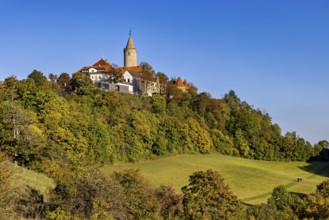 A castle in a hilly wooded area, surrounded by autumn landscape and blue skies, The Leuchtenburg