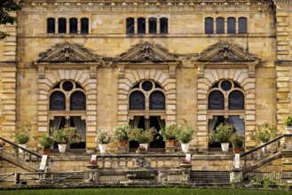Detail of the castle façade with lush flowers in pots in front of large windows, The Hummelshain