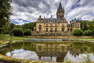 Large castle with pond reflection under a dramatic sky, The Hummelshain hunting lodge in Thuringia
