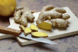 Ginger, ginger root cut with ginger slices on wooden boards
