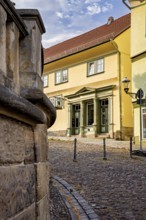 Yellow historic building on a paved street with classic architecture, The old town of Arnstadt in