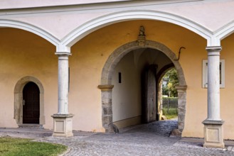 Close-up of an archway of a historic building with paved floor, gate to the district office in the
