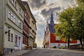 Street with historic facades and church tower under a dramatic sky in the old town, The old town of