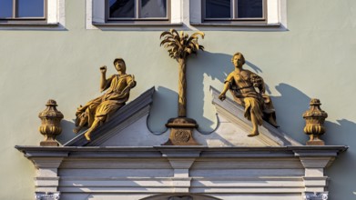 Detailed façade decoration with two statues and a decorative palm tree, statue and monument in the