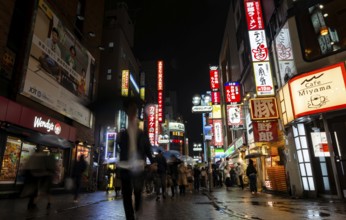 Busy pedestrian zone with many shopping centers and stores, illuminated with lots of neon signs at