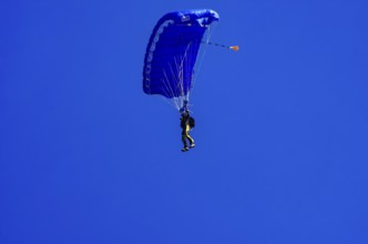 Skydivers during an aerial acrobatic performance as part of an air show at the Fliegerbergfest of