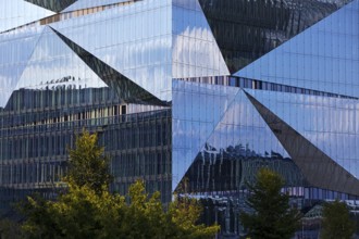 Cube Berlin, cube-shaped office building with folded glass façade reflecting the surroundings,