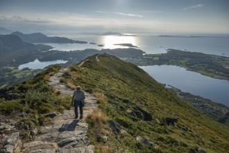 Woman with hiking poles walking up Rørsethornet stone stairs, with 3292 steps one of the longest
