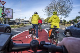 Riding a bike in a bike lane, marked in red to attract the attention of motorists, between 2 lanes,
