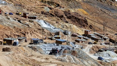 Spacious settlement with huts and vehicles in a barren, stony terrain, The silver mines of Potosi