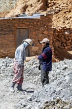Two men in work clothes talk in a dusty mining landscape, The miners of the Cerro Rico silver