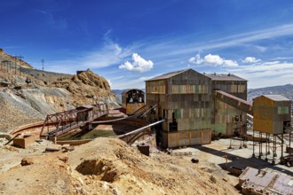 Abandoned industrial plant with rusty buildings against a blue sky and clouds, The silver mines of