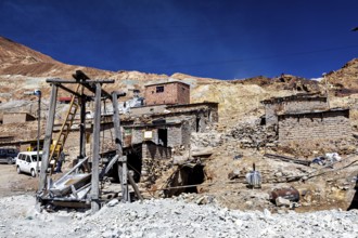 Weathered stone houses and huts on a mountainside with a clear sky, The silver mines of Potosi