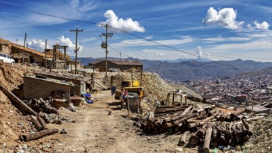 Rustic village scene with huts and mountains in the background under a cloudy sky, The silver mines