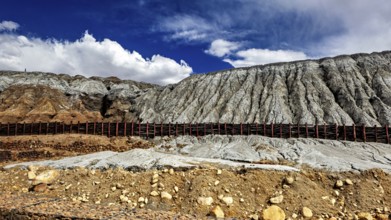 Rocky mountain formation with a contrast between barren slopes and blue sky, spoil heap of the