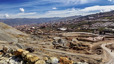 View of a town along a mountainous landscape under a clear blue sky with few clouds, The silver