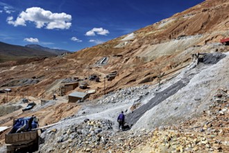 A worker moves on a stony hill with a wide view over the landscape, The silver mines of Potosi