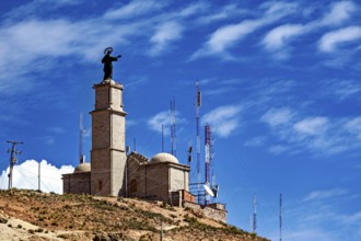 Tower with statue and antennae on a hill under a clear blue sky, The church on the Cerro Rico