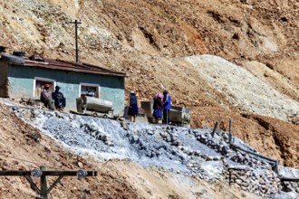 Miners with wheelbarrows on a rocky slope during mining work, The silver mines of Potosi Bolivia