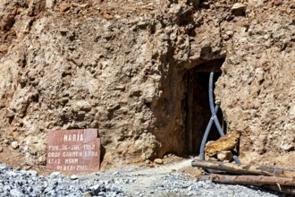 Mine entrance with shield and metallic beams in a rocky environment, The silver mines of Potosi