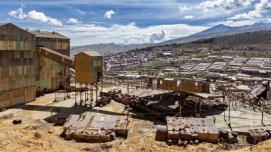 Industrial building in the foreground with sweeping views over a valley and mountains, The silver