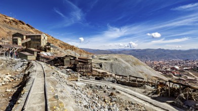 View of abandoned mine buildings and railway tracks in a hilly landscape, The silver mines of