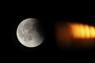 After a total lunar eclipse, the moon appears shortly after its rise in the evening sky as a