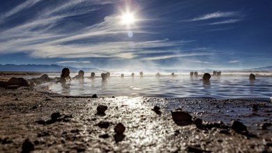 People enjoy hot springs at sunset with a wide sky, The thermal springs of Polques in Bolivia