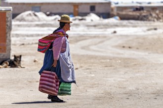 Man in traditional dress walks along a dusty road in a desert landscape, Traditional woman in a