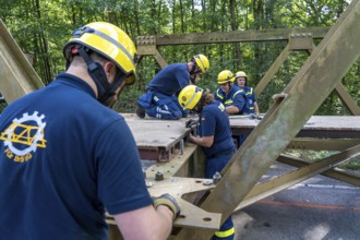 Construction of a temporary bridge over a slipped road crossing a stream, by the bridge