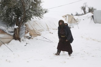 Displaced Syrian families and children living in refugee camps during harsh winter conditions,