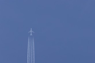 Airbus A340-300 jet aircraft of Lufthansa airlines in flight in a blue sky with vapour trails or