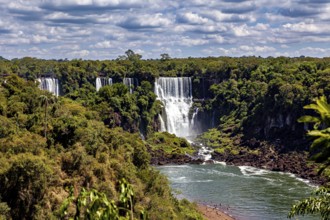 Impressive waterfalls in dense vegetation under a cloudy sky, The Iguazu Falls between Argentina