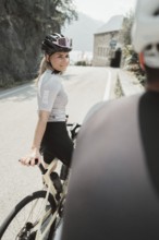 Woman and man cycling on Lake Garda in Italy. Sunny weather and dolce vita