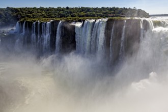 Impressive waterfall with dense haze and lush forest background under a clear sky, The Iguazu Falls