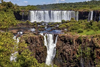 Waterfalls in a rocky landscape with river and lush vegetation, clear sky, The waterfalls of Iguazu