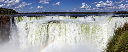 Impressive panoramic view of a chain of waterfalls under a cloudy sky, The Iguazu Falls between