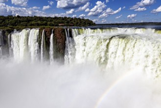 Impressive waterfalls with spraying spray under a cloudy sky, The Iguazu Falls between Argentina