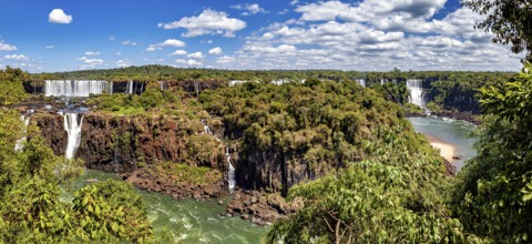 Sweeping views of waterfalls and river, surrounded by lush vegetation under a cloudy sky, The