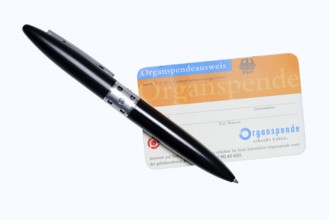 Organ donor card with biros on white background, symbolic image of organ donation