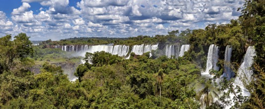 Wide panorama of waterfalls in the middle of a tropical jungle under a cloudy sky, The Iguazu Falls