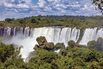 Majestic waterfall surrounded by dense forests and cloudy skies, The Iguazu Falls between Argentina