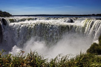 Impressive waterfall plunges into the depths, surrounded by rising spray, The Iguazu Falls between