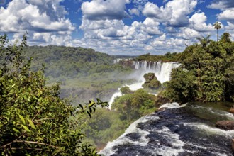 Rushing waterfall in dense vegetation under a vast sky, The Iguazu Falls between Argentina and