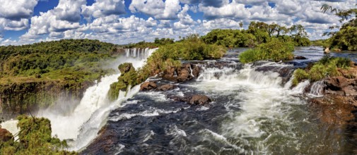 Panoramic view of rushing river and waterfall under a dramatic sky, The Iguazu Falls between