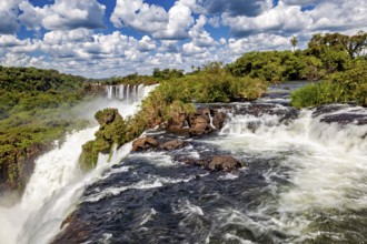Waterfall in a natural setting under a picturesque cloudy sky, The Iguazu Falls between Argentina